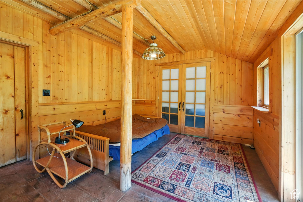 Bedroom featuring french doors, wood walls, and wood ceiling