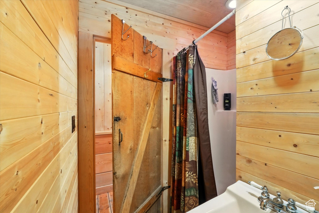 Full bathroom with wood walls and curtained shower