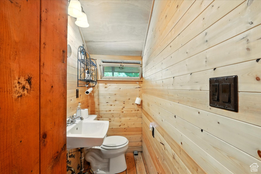 Half bathroom with wood walls and toilet