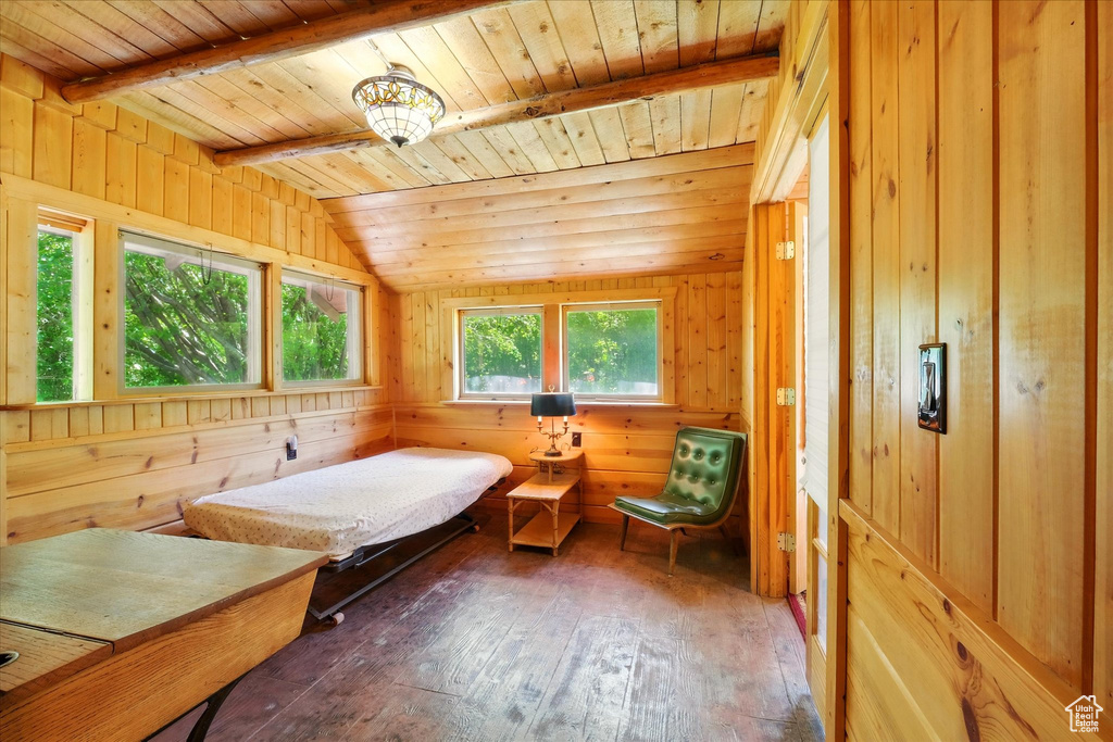 Bedroom featuring wooden ceiling, wood-type flooring, and wooden walls