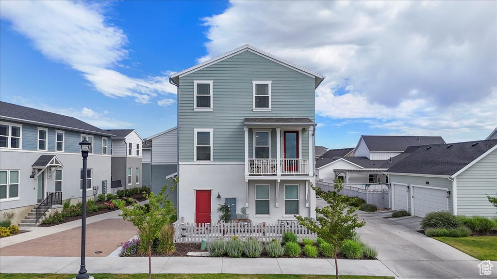 Multi unit property featuring a balcony, a residential view, stucco siding, and driveway
