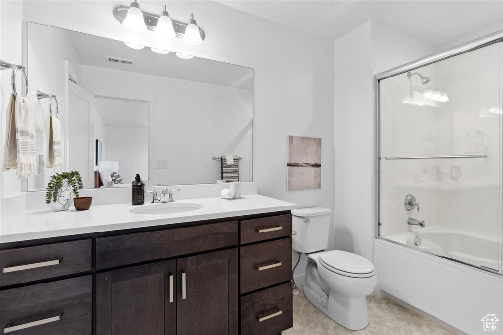 Full bathroom featuring vanity, shower / bath combination with glass door, and tile patterned floors
