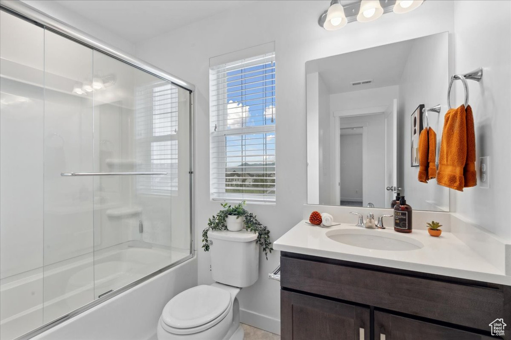 Bathroom featuring vanity and enclosed tub / shower combo