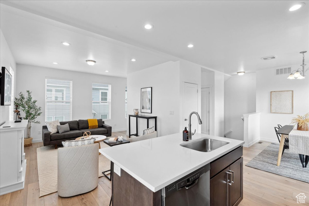 Kitchen featuring stainless steel dishwasher, light wood-style flooring, light countertops, dark brown cabinets, and recessed lighting