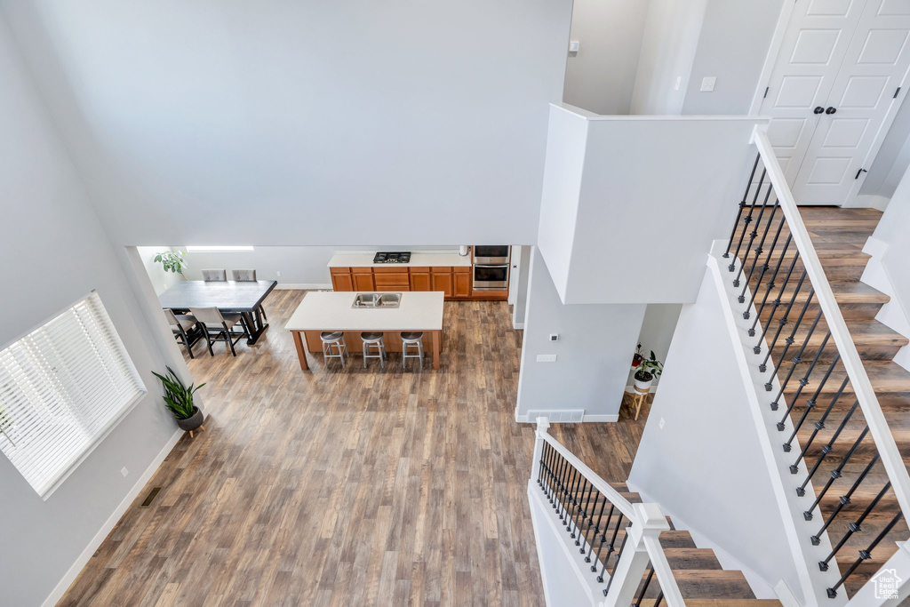 Stairs featuring wood finished floors and a high ceiling