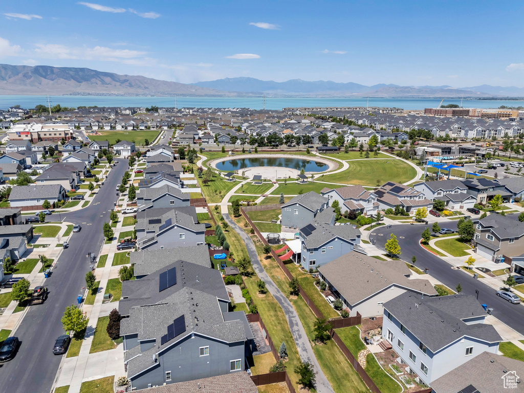Aerial view of property and surrounding area featuring nearby suburban area and a water and mountain view