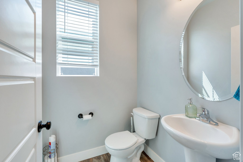 Half bath with a sink and wood finished floors