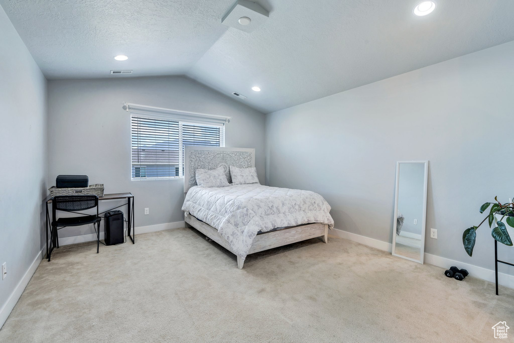 Carpeted bedroom with lofted ceiling, a textured ceiling, and recessed lighting