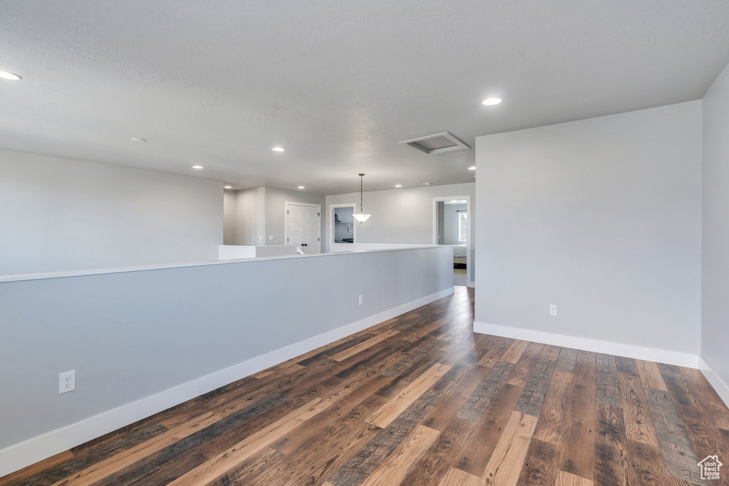 Unfurnished room featuring attic access, dark wood finished floors, and recessed lighting