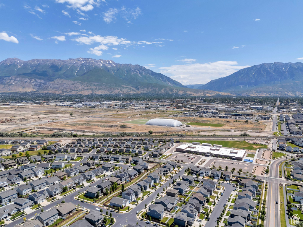 Aerial view of property and surrounding area with a mountainous background and nearby suburban area