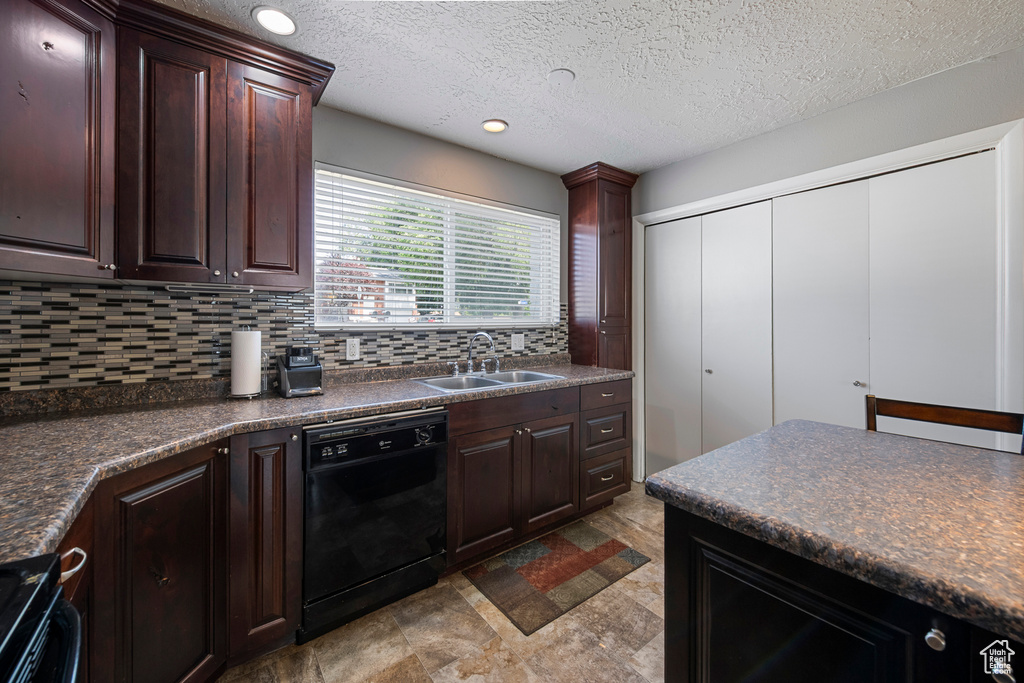 Kitchen featuring black appliances, dark countertops, a sink, backsplash, and dark brown cabinets