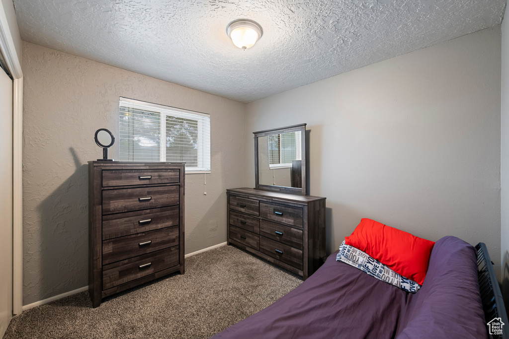 Bedroom featuring a textured ceiling, carpet flooring, and baseboards
