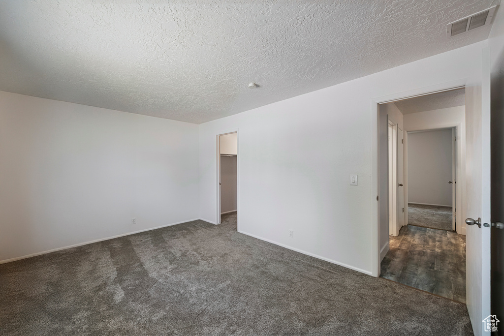 Carpeted spare room featuring baseboards and a textured ceiling