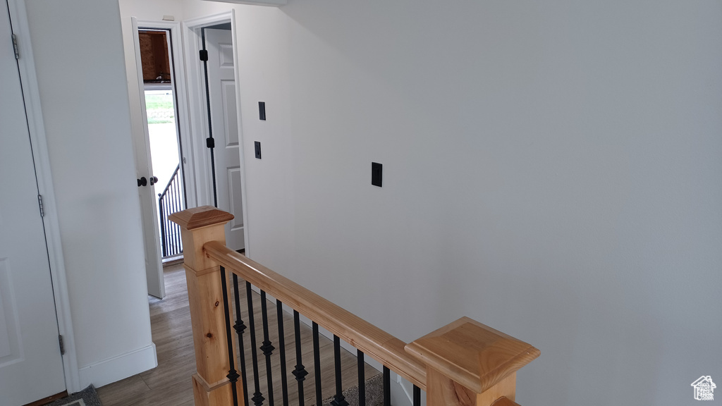 Hallway with an upstairs landing and wood finished floors