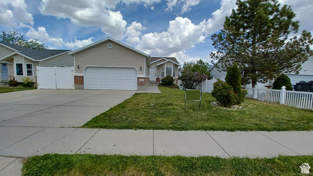 View of front of home with an attached garage, brick siding, and concrete driveway