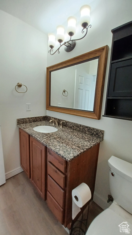 Half bathroom with vanity and wood finished floors