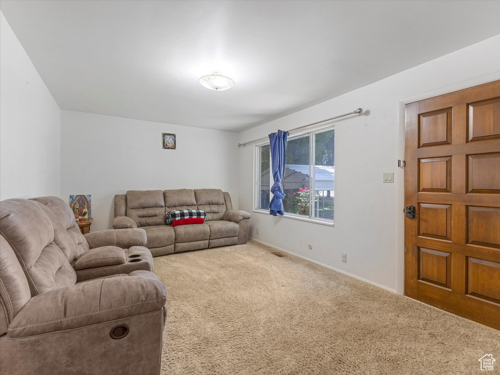 Carpeted living area featuring baseboards