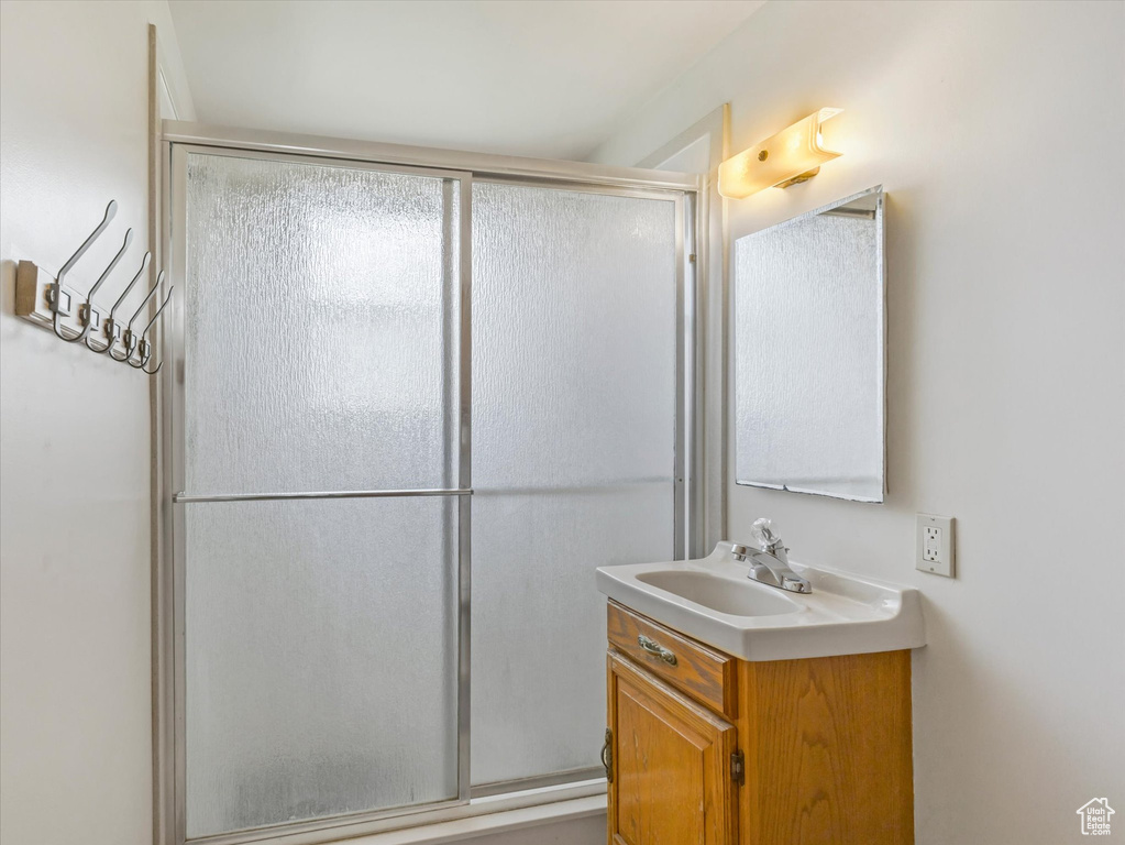 Full bathroom with vanity and a shower with door