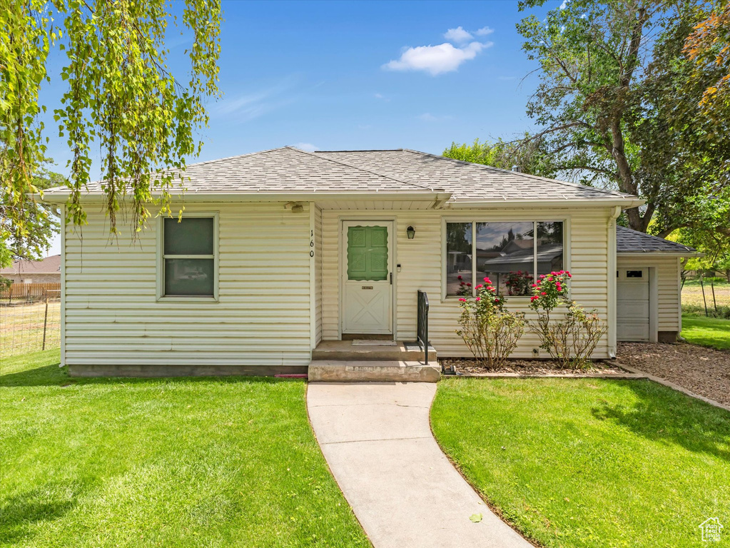Bungalow with roof with shingles and a front lawn
