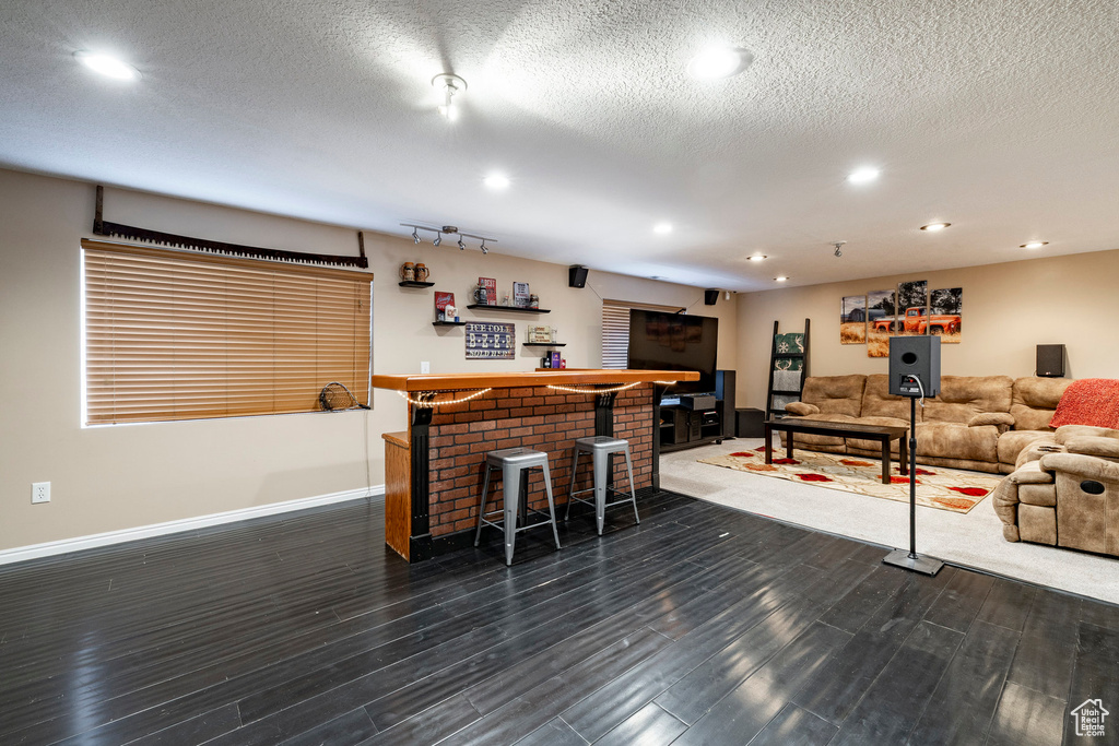 Indoor dry bar with recessed lighting and dark wood-style floors