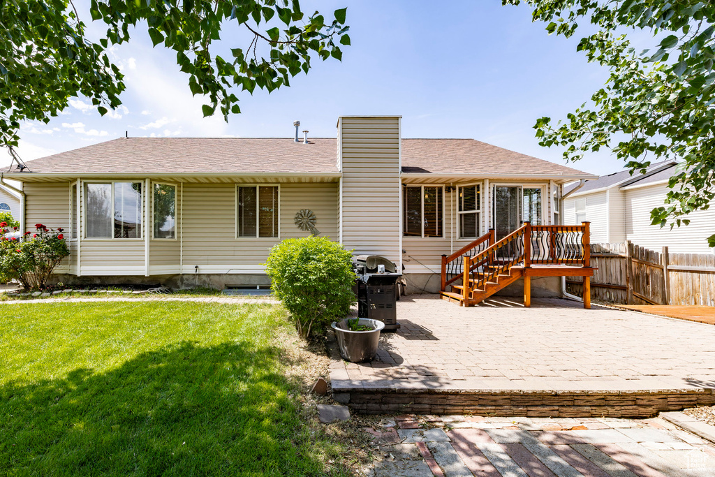 Back of house with a chimney, a patio area, and a shingled roof