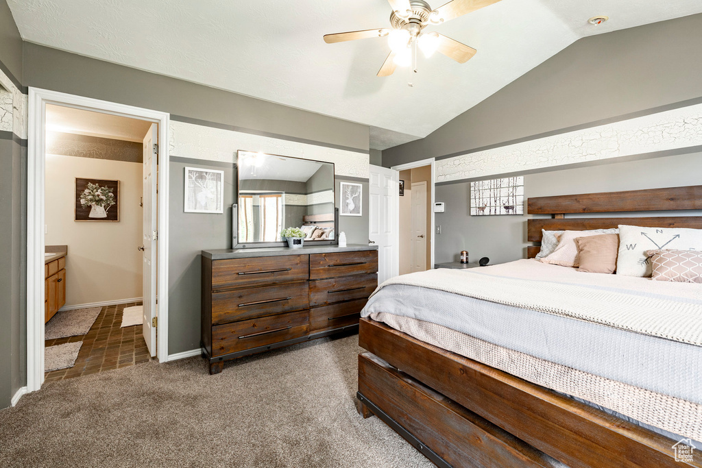 Carpeted bedroom with lofted ceiling, connected bathroom, and ceiling fan