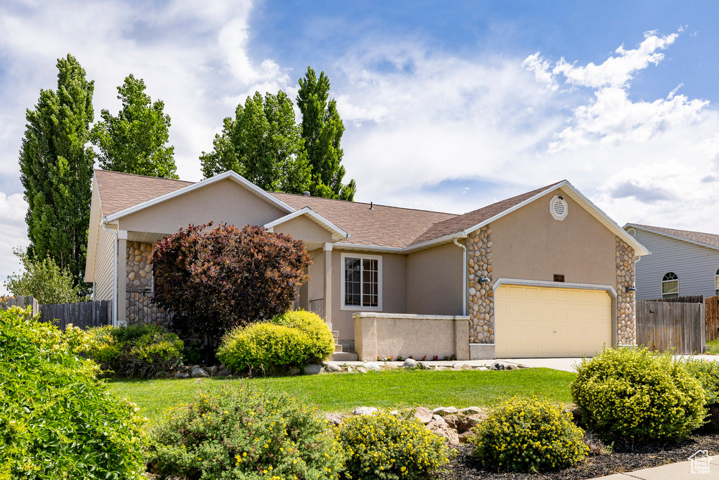 View of front of property featuring stone siding, stucco siding, a garage, and a shingled roof