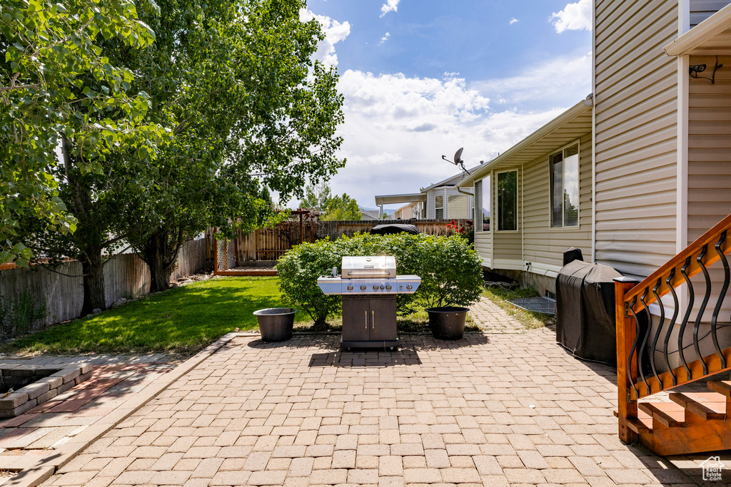 Fenced backyard featuring grilling area and a patio