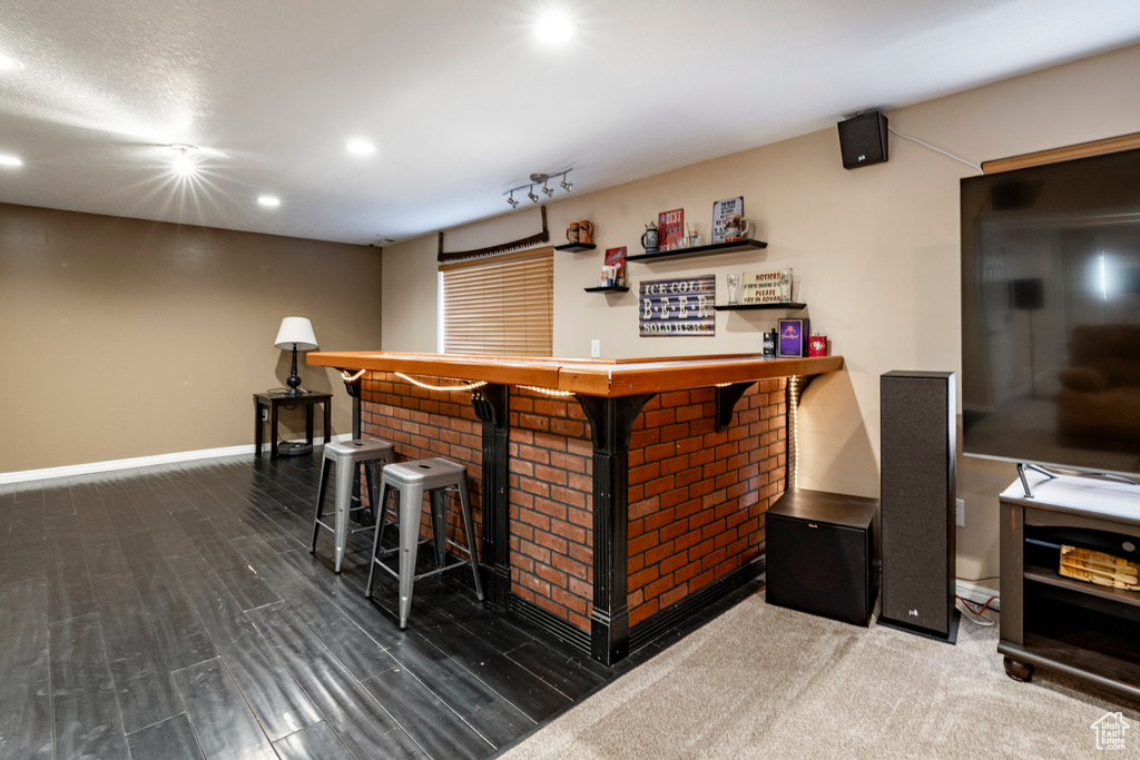 Indoor dry bar with recessed lighting and baseboards