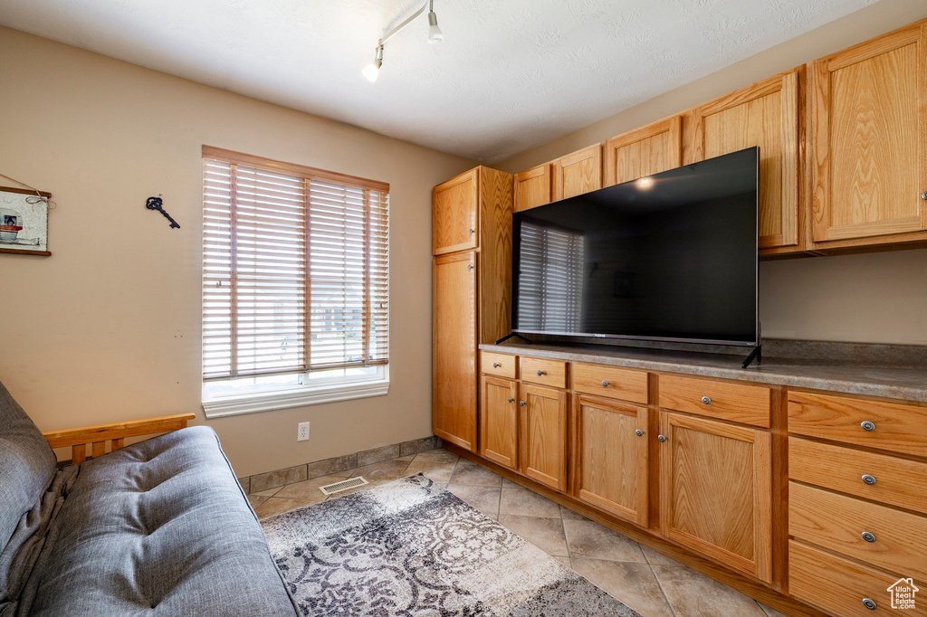 Living area featuring rail lighting and light tile patterned floors