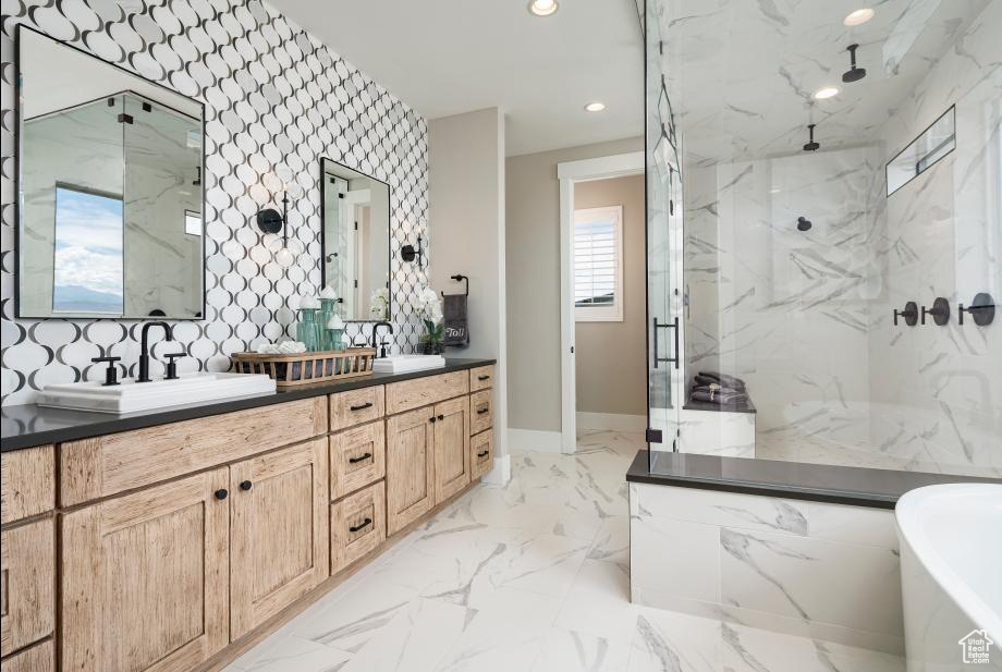 Bathroom featuring a marble finish shower, double vanity, a freestanding tub, recessed lighting, and marble finish floors