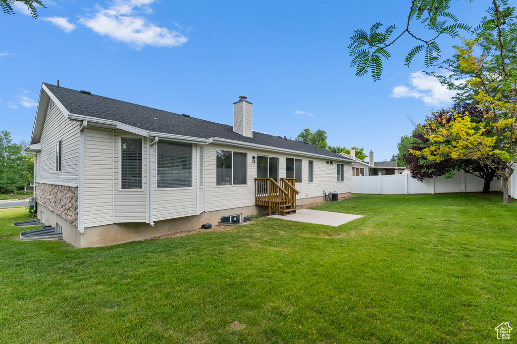 Back of property featuring a chimney and a patio area