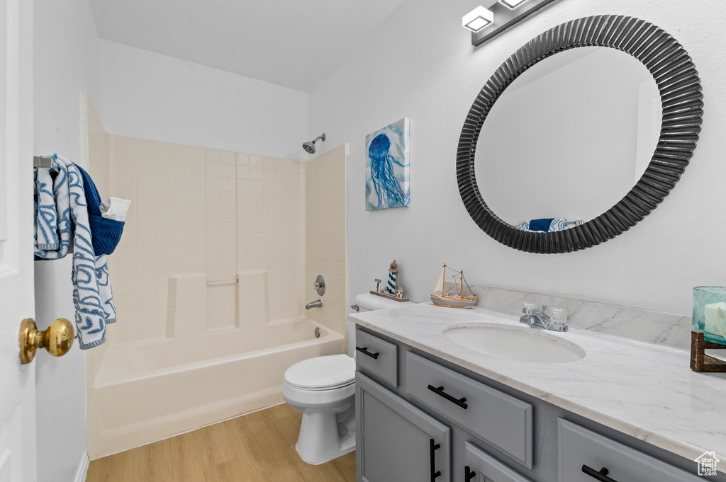 Bathroom featuring vanity, wood finished floors, and tub / shower combination