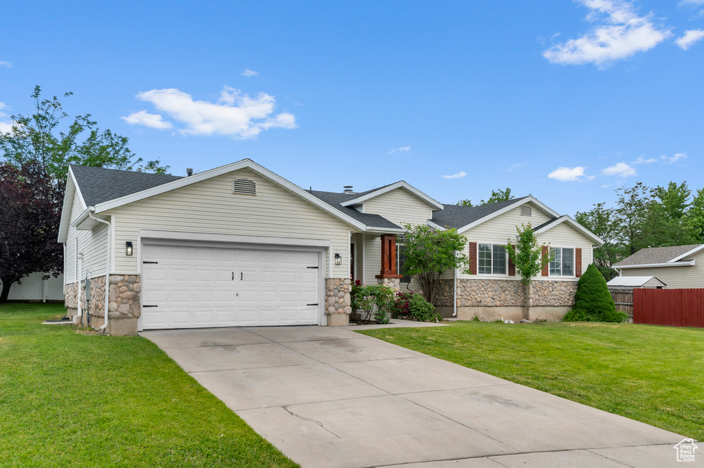 Ranch-style house featuring stone siding, a garage, driveway, and roof with shingles