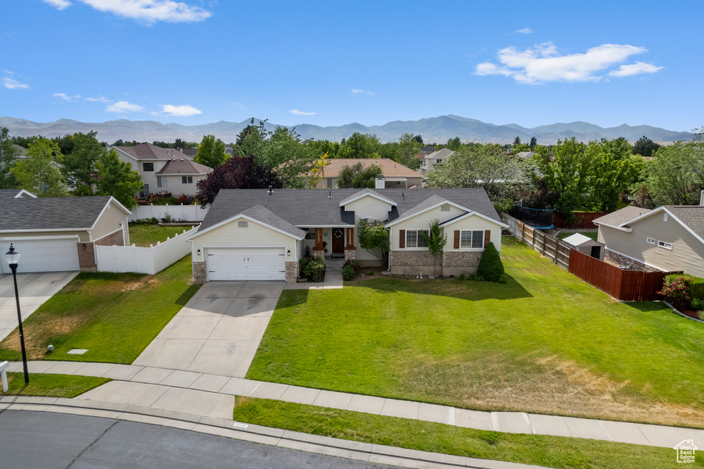 View of front of house with a residential view, concrete driveway, a garage, and a mountain view