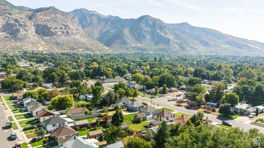 Aerial view of property and surrounding area with mountains and nearby suburban area