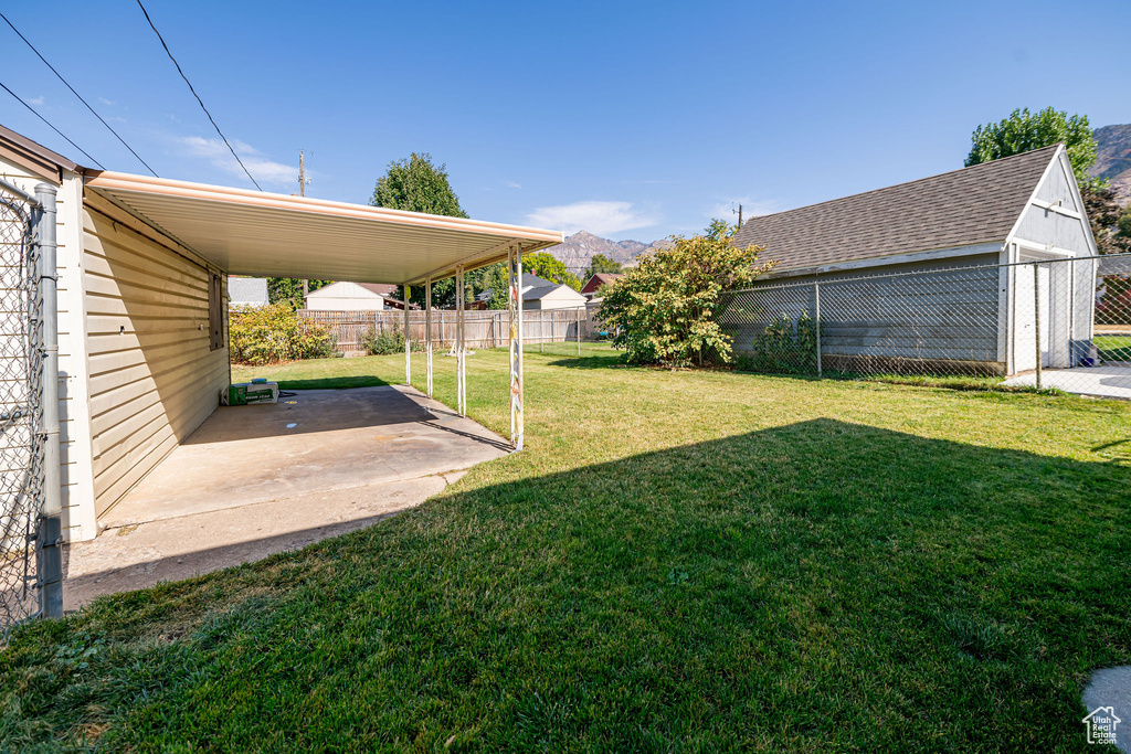 View of yard with a patio, a mountain view, and an attached carport