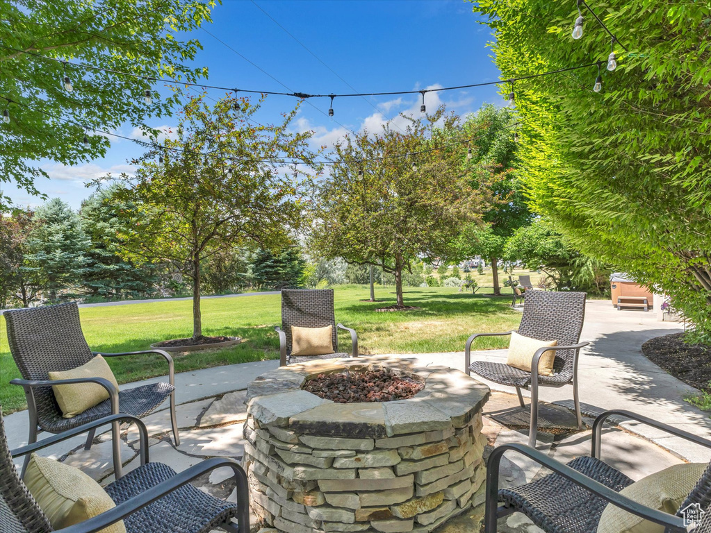 View of patio with a fire pit and view of wooded area