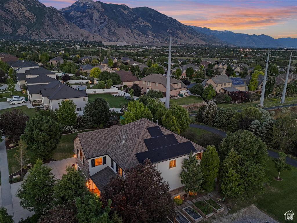 Aerial view of property and surrounding area featuring a mountainous background and nearby suburban area