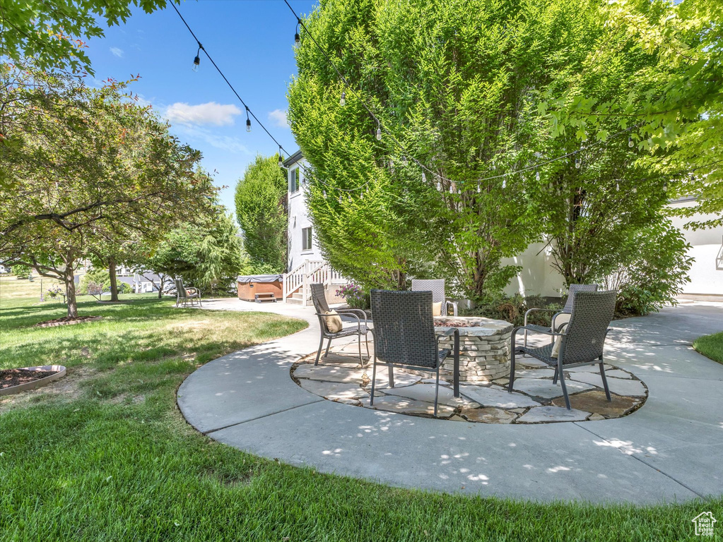 View of patio with a hot tub and a fire pit