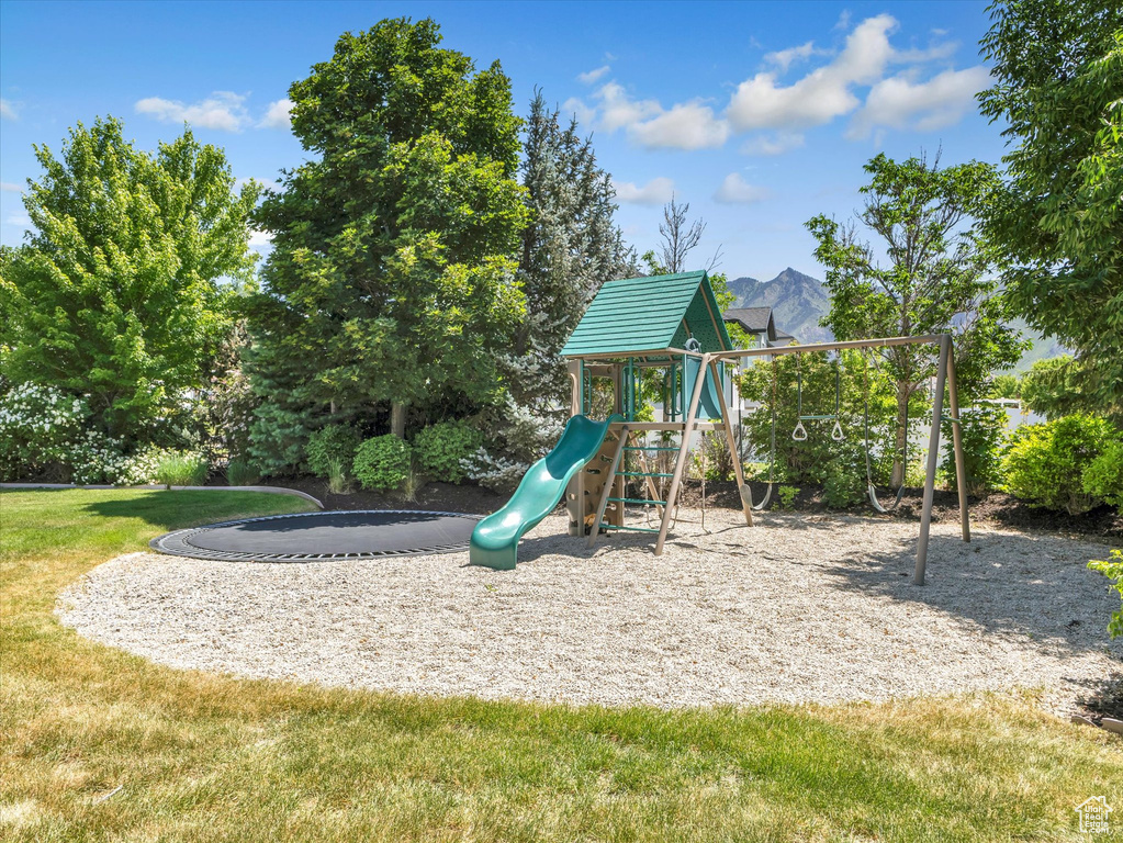 Community playground with a mountain view and a yard