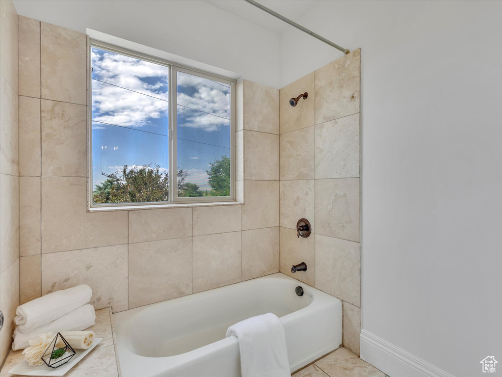Bathroom featuring healthy amount of natural light and shower / bath combination