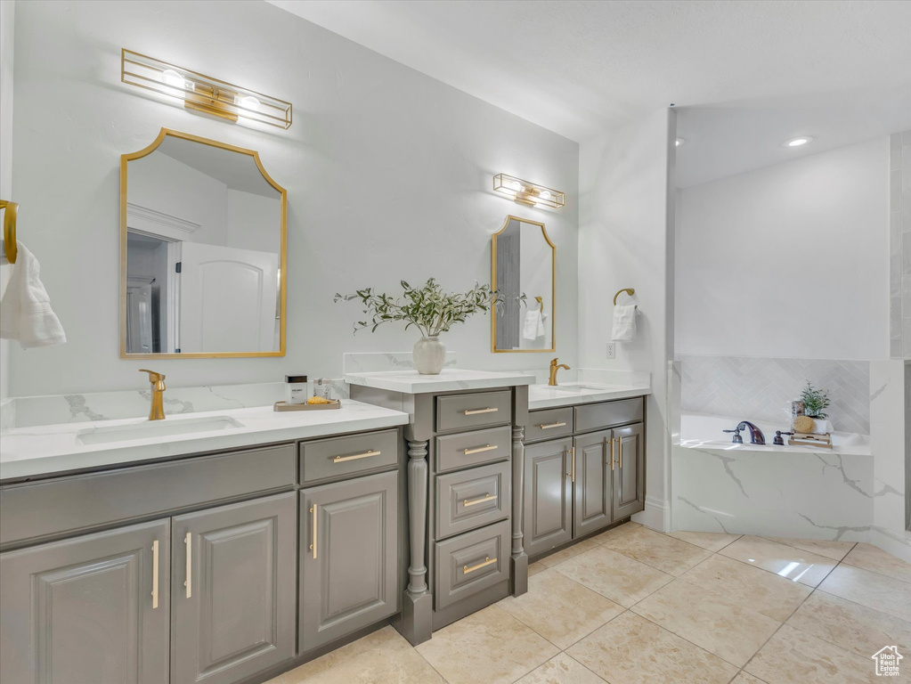 Bathroom with two vanities, a bath, and tile patterned floors