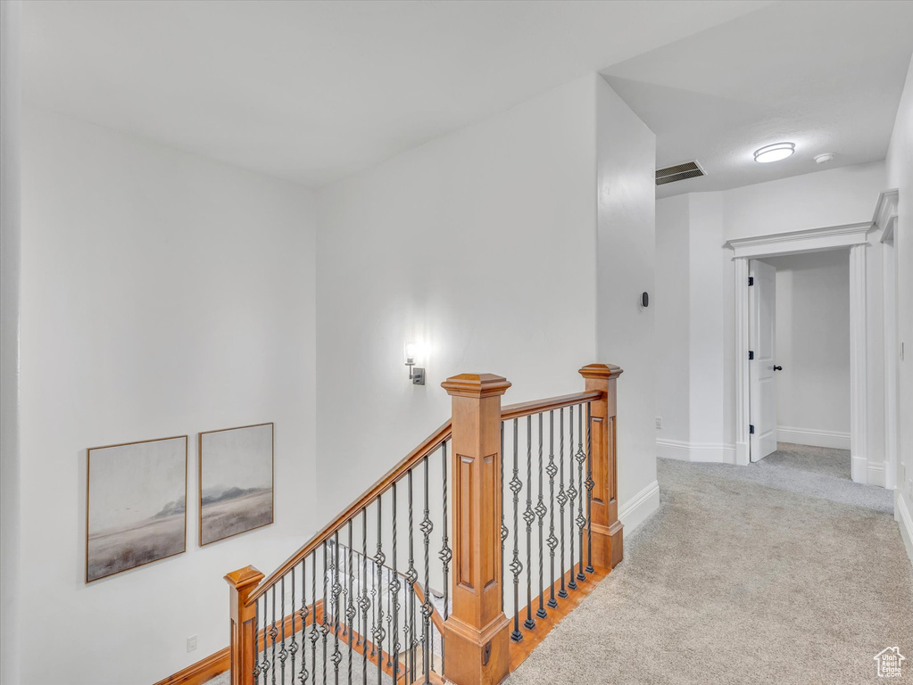 Corridor featuring an upstairs landing and carpet floors