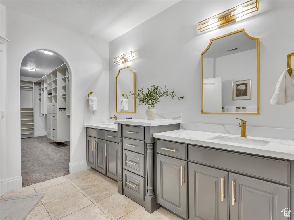Bathroom featuring vanity, a walk in closet, and tile patterned floors
