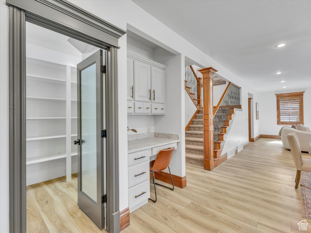 Corridor with recessed lighting, light wood-style floors, stairs, and a desk