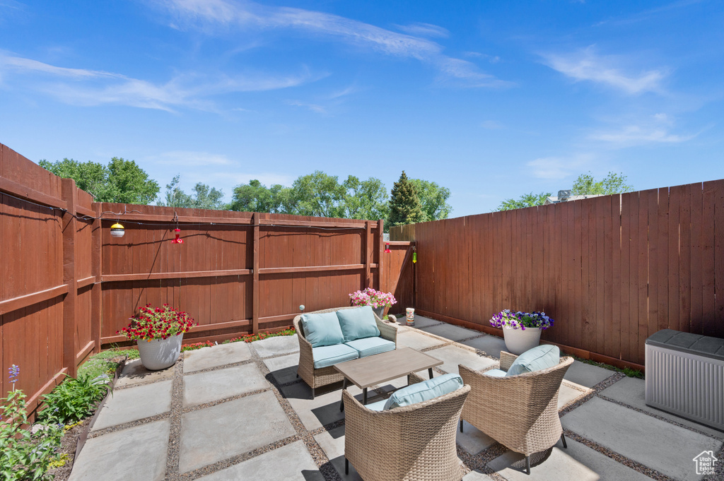 Fenced backyard with an outdoor living space and a patio area