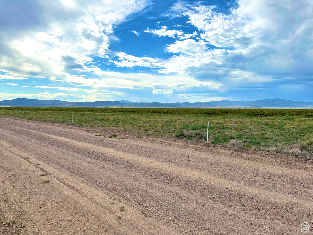 View of dirt / gravel road with a mountain view and a view of rural / pastoral area