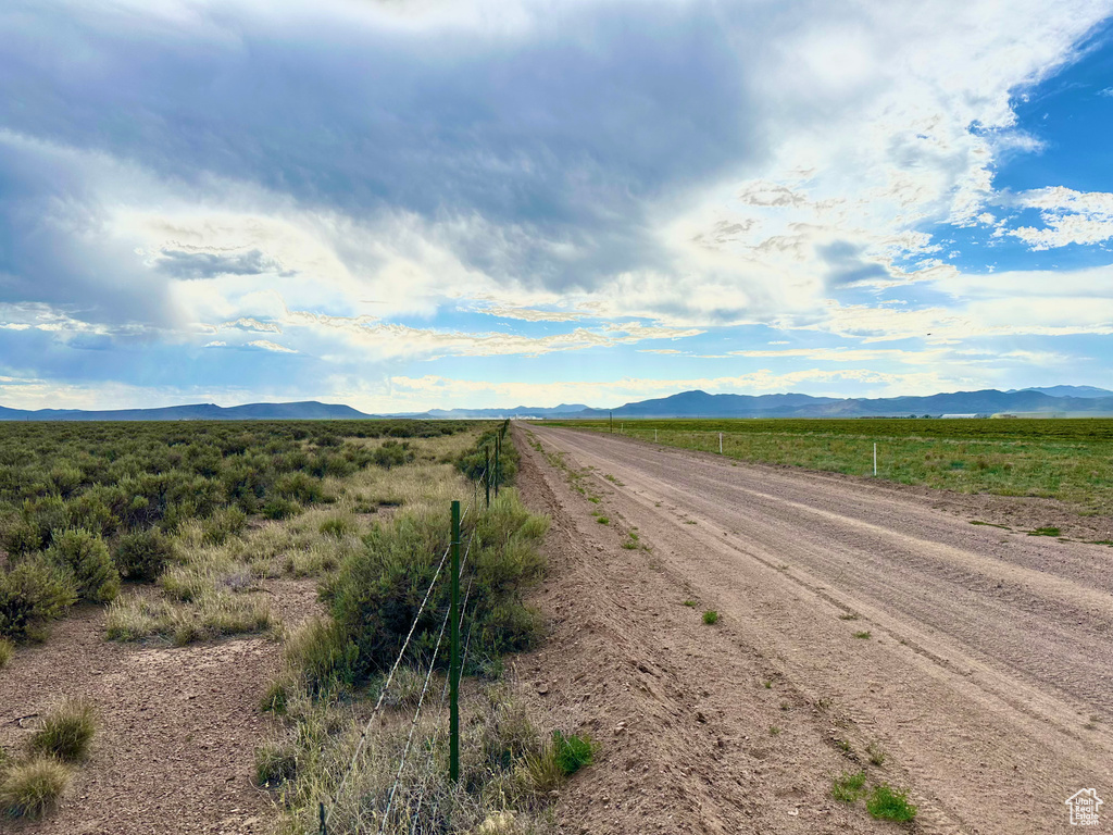 View of dirt / gravel road with a mountain view and a view of rural / pastoral area