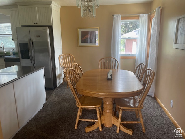 Dining area featuring dark carpet and a chandelier